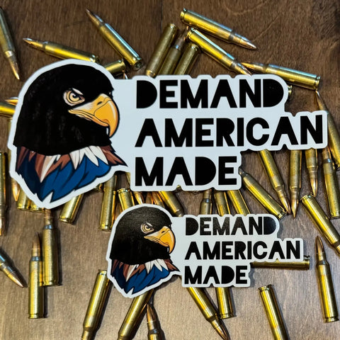 Add patriotic flair to favor or gift bags with the American Lictor Sticker: Demand American Made, featuring a bold bald eagle head and text, shown on wood with scattered rifle bullets.