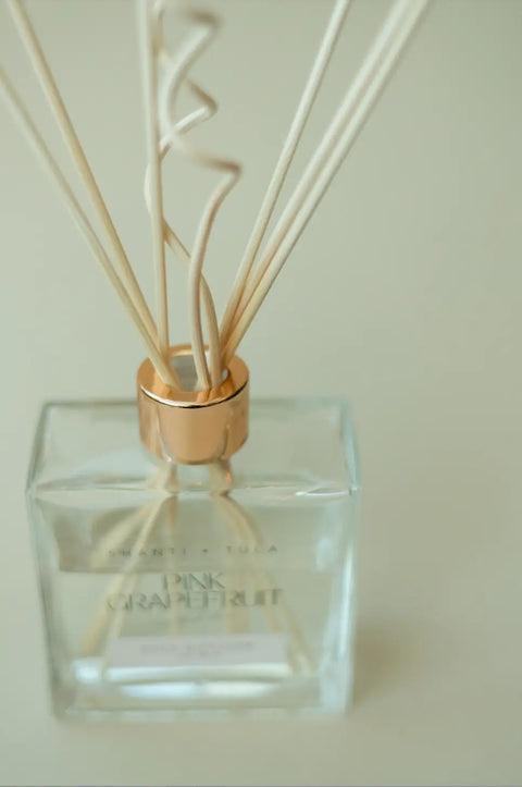 The Shanti + Tula Diffuser Replacement Reeds – Curly & Straight Set, made in the USA, are displayed against a soft beige background, highlighting their elegant design and effective fragrance diffusion.