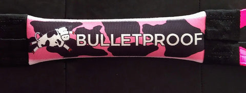 Upgrade your pup’s play with the Dock Diving Bumper Tug - Competition Series Weighted - Cow Dog Crack from Bulletproof Pet Products Inc, featuring a pink and black camo strap with a cartoon cow and bold BULLETPROOF lettering.