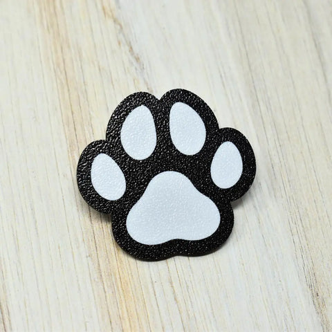 The FRESHe BAGLETS Dog Paw Charm by Chatelet Manufacturing, a black and white decorative accessory, is perfect for Bogg Bags, Simply Southern, and other tote bags—made in the USA.