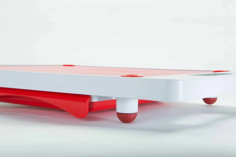 A close-up of the Karving King Dripless Cutting Board 2 in 1 System, featuring white and red colors, short legs with red rubber tips, set against a plain light background.