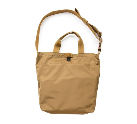 The MIS 2 Way Shoulder Bag in coyote brown is made in the USA from water-resistant packcloth nylon. It features short handles, a long adjustable strap, and a small black front logo tag.