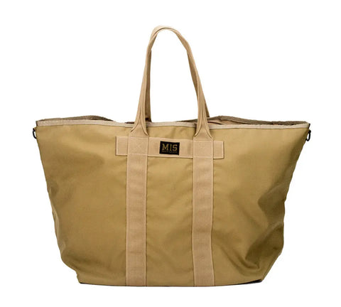The MIS Super Tote Bag - Coyote Tan is a 40L, water-resistant canvas tote with two sturdy handles, a black front label, and a spacious unstructured design. Made in the USA for everyday versatility.