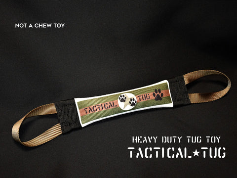 A heavy-duty Tactical Fire Hose Training Tug by Bulletproof Pet Products Inc, with two looped handles and central label, rests on a dark surface. Image text: NOT A CHEW TOY. HEAVY DUTY TUG TOY. Durable dog toys made in USA.