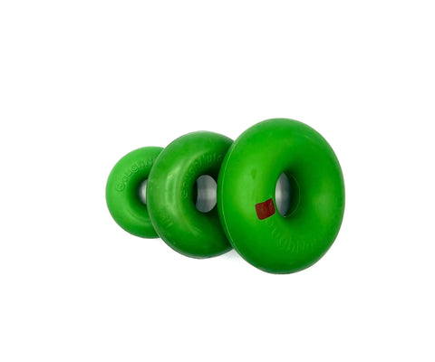 Three Goughnuts Green Rings, made of natural rubber and varying in size, are arranged diagonally on a white background. One durable ring dog toy displays a small red square mark.