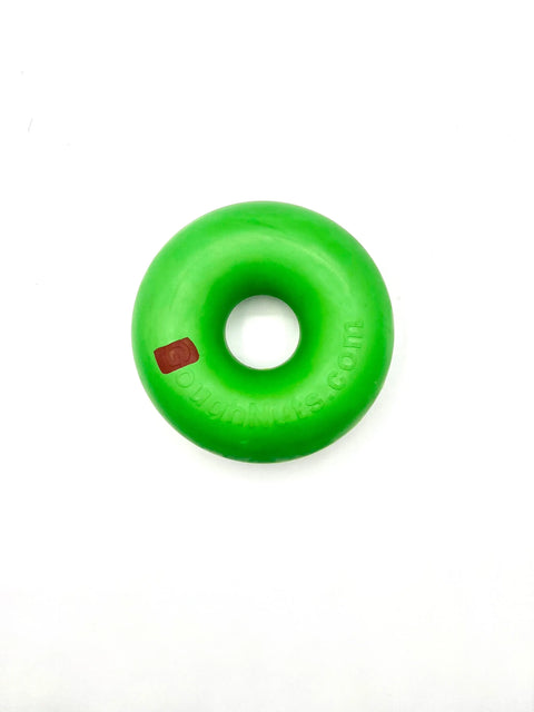 A bright green, round, donut-shaped dog toy called Green Rings by Goughnuts sits on a white background with a small red rectangle on the left side of the ring.
