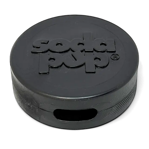 The SodaPup Hockey Puck Durable PUP-X Rubber Treat Holder and Chew Toy is a black, round chew toy with a rectangular side opening and embossed branding, designed for long-lasting play.