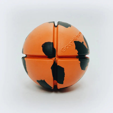 The Goughnuts Interactive Orange Ball is a durable dog toy with irregular black spots and four deep grooves. The brand name is embossed on its surface. Made in the USA, it’s shown on a plain white background.