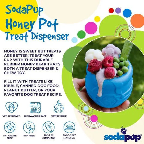 A hand holds the blue SodaPup Honey Pot Durable PUP-X Rubber ECup Treat Dispenser & Enrichment Toy, shaped like a bear and filled with yogurt, blackberries, and raspberries. Informational text and colorful graphics highlight this fun slow feeder.