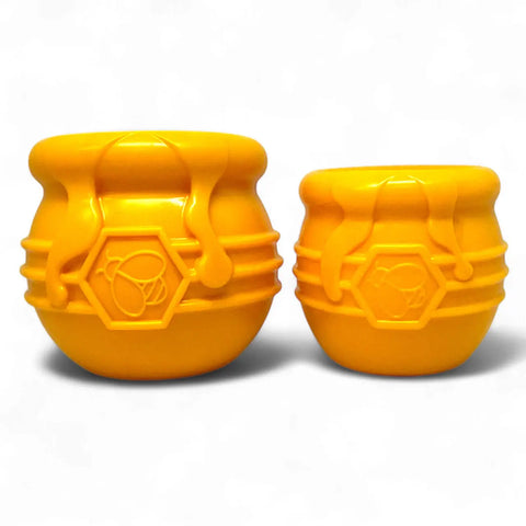 Two yellow Honey Pot Durable PUP-X Rubber ECup Treat Dispenser & Enrichment Toys by SodaPup with bee emblems and hexagon patterns are shown on a plain white background, ideal as treat dispensers or slow feeders.