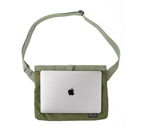 A silver MacBook is partially tucked inside the MIS Padded Shoulder Bag - Multi Cam, a water-resistant, durable Cordura Nylon laptop bag with an adjustable strap, shown on a white background.