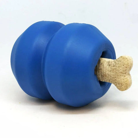 The SodaPup Double Trouble EDispenser is a blue durable rubber chew toy with a hollow center, designed to dispense treats, shown here with a beige bone-shaped treat partially inserted into one end.