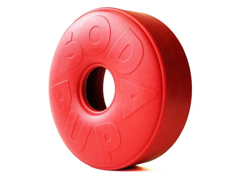 The SodaPup Life Ring EDispener is a red, donut-shaped durable rubber chew toy and treat dispenser with SODA PUP embossed, shown against a white background. It helps reduce problem behaviors in dogs by dispensing treats.