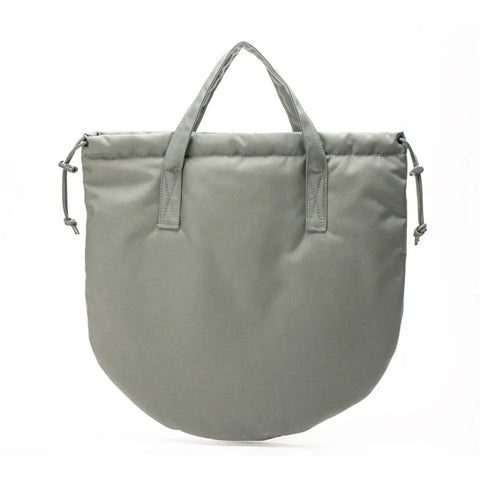 The MIS UK Helmet Bag - Foliage is a light gray, rounded Cordura Nylon bag with short handles, adjustable side drawstrings, and a sleek drawstring closure, shown against a white background.