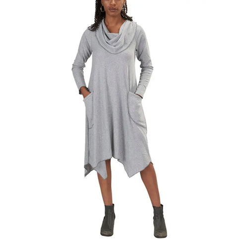 A person wears the Spiritex 50/50 Long Sleeve Colette Drape Dress in light gray, featuring side pockets and an asymmetrical hem, styled with ankle boots. Its draped A-line silhouette creates a casual, comfortable look.