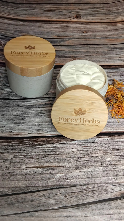 Two jars of Forev'Herbs Eczema Cream with bamboo lids—one open to reveal the white cream—rest on a rustic wooden surface beside yellow petals. Crafted with natural ingredients, it's gentle on sensitive skin.