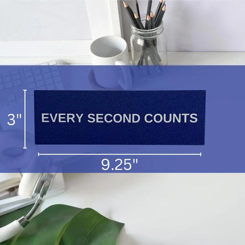 A navy blue Chatelet Manufacturing Every Second Counts Wall Sign (3 x 9.25) sits next to a mug and plant—ideal as inspirational kitchen decor or The Bear wall sign.
