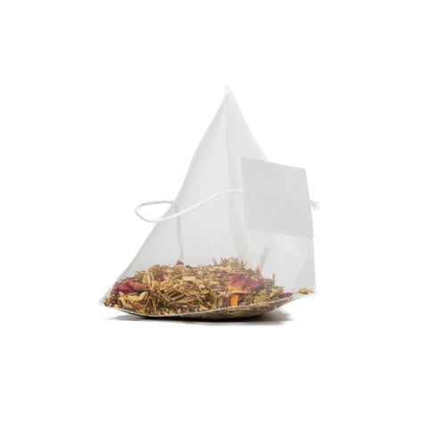 A close-up of a pyramid-shaped Exotic Everglades (Rooibos Fruit Tea) bag by Sasquatch Tea Co, filled with caffeine-free leaves and petals, with a white string and blank tag, set against a plain white background.