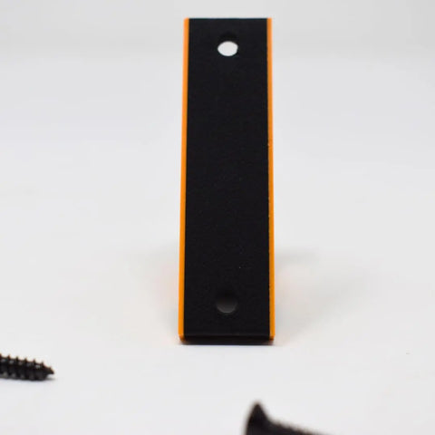 The FRESHe Horizontal Fishing Rod Holder by Chatelet Manufacturing is a USA-made black rectangular holder with orange edges and two holes, shown upright on a white surface with screws visible at both bottom corners.