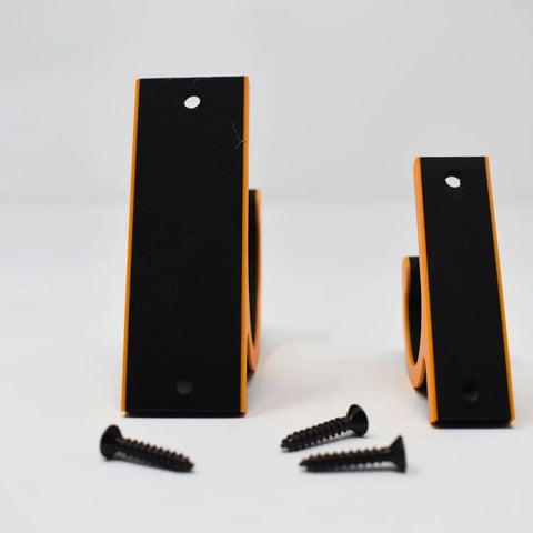 Two FRESHe Horizontal Fishing Rod Holders by Chatelet Manufacturing stand upright on a white surface, each black and orange bracket featuring two screw holes. Four black screws are placed in front of the holders.