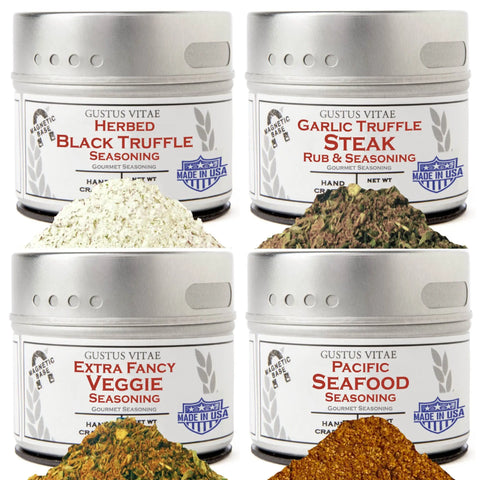 The Fancy Proteins & Truffled Sides 4 Pack features four tins of vendor-unknown seasonings, each displayed with a matching pile of its blend: Herbed Black Truffle, Garlic Truffle Steak Rub, Extra Fancy Veggie, and Pacific Seafood Seasoning.
