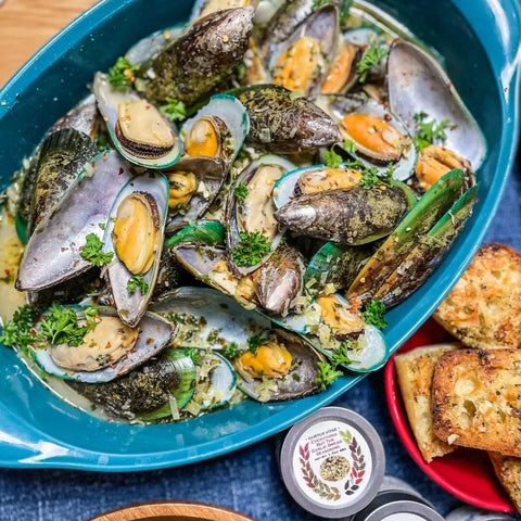 Enjoy a dish of steamed mussels garnished with parsley, served with toasted bread alongside gourmet seasoning jars from vendor-unknown’s Fancy Proteins & Truffled Sides | 4 Pack.