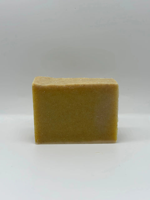 The O’ Suds Bar by Five O Clock Co., a rectangular, beige-brown small-batch soap bar, stands upright against a plain white background, highlighting the care and quality of natural soap bars.