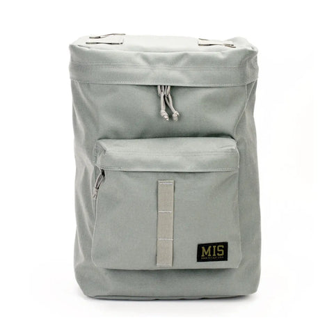 The MIS Backpack - Foliage is a light gray Cordura nylon bag with a rectangular shape, front zip pocket, padded laptop holder, and a black and yellow MIS label on the lower front pocket. Made in the USA, shown against a white background.