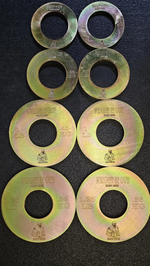 Eight Fractional Solid Steel Mini Olympic Weight Plates by Weight It Out, labeled 0.5 kg, 0.25 kg, 1 lb, and 1.25 lb, are paired on a black surface—perfect for gradual loading on any Olympic bar.