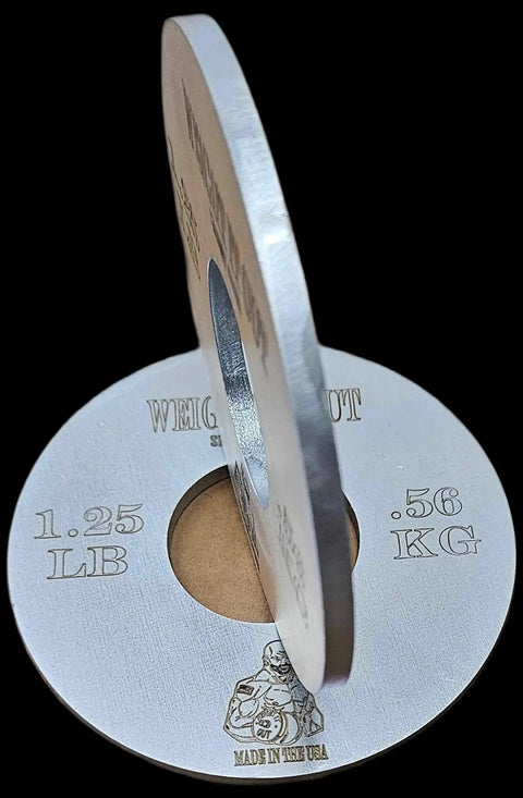 Two silver-colored Fractional Solid Steel Mini Olympic Weight Plates by Weight It Out, labeled 1.25 LB/.56 KG and “Made in the USA” with an engraved illustration—perfect for gradual weight increase on any Olympic bar.