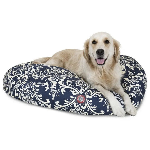 A golden retriever relaxes on the Majestic Pet French Quarter Round Dog Bed in navy blue with a white ornate floral pattern. It features a washable, removable cover for easy cleaning.