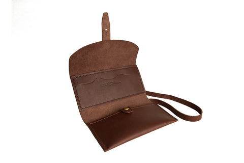 The Urban Southern Crossbody Wallet in brown leather features a strap and opens to reveal interior pockets and card slots for easy organization, shown against a white background.