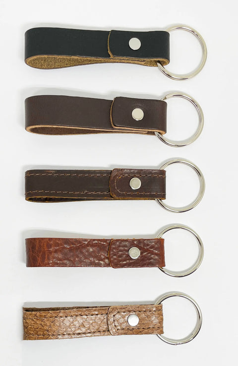 Five Rogue Industries Leather Key Chains, made from durable top-grain cowhide in assorted brown and black shades and textures, are arranged vertically on a white background.