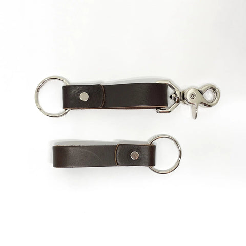 Two Rogue Industries Leather Key Chains in dark brown top-grain cowhide with silver rings and studs, one with an extra silver clip, displayed on a white background.