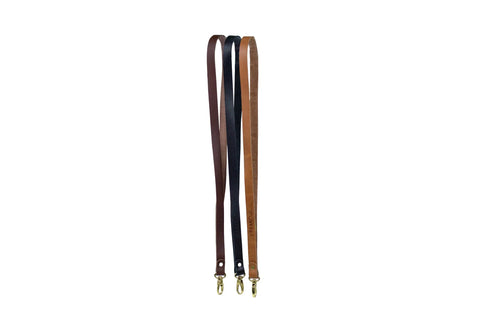 Two American-made Urban Southern Leather Lanyards, one dark brown and one light brown, with gold-tone metal clasps at the ends, displayed on a white background.