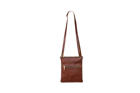 The Urban Southern Urban Slim Crossbody is a lightweight brown leather bag with a long adjustable strap and a front zippered pocket, shown on a white background.