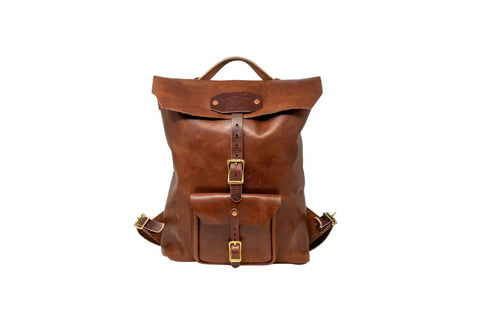 The Urban Southern Urban Rucksack features brown full-grain leather, a fold-over top, front buckle closure, small front pocket with buckle, adjustable straps, and brass hardware, shown against a white background.
