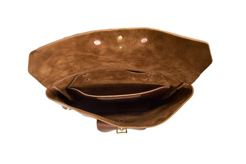 The Urban Southern Urban Rucksack is shown open from above, revealing its brown full-grain leather exterior, suede-lined interior, spacious main compartment, and inner pocket. The empty bag is displayed against a white background.