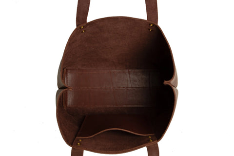 Top view of the Urban Southern Urban Tote, an American-made full-grain leather bag with two handles, gold-toned rivets at the attachments, a visible interior pocket, and meticulous stitching.