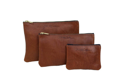 Three brown Urban Southern Zipper Pouch bags of different sizes stand upright against a white background. Each pouch features a sleek gold zipper closure and has the Urban Southern brand embossed on the front.
