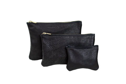 Three Urban Southern Zipper Pouches in black garment leather, each a different size, are arranged together on a white background. All pouches feature elegant gold zipper closures.