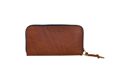 The Urban Zipper Wallet by Urban Southern is a brown leather wallet featuring credit card slots, a zippered closure, wrist strap, and embossed branding on the front, shown against a white background.