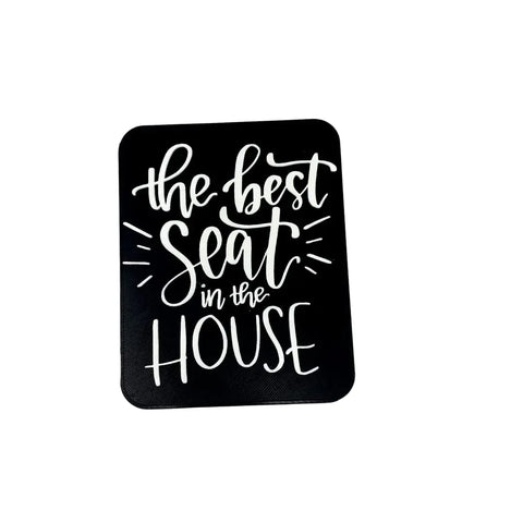 The Best Seat in the House Decorative Bathroom Sign by Chatelet Manufacturing features playful white lettering on a black background, making a funny and charming accent for any bathroom.