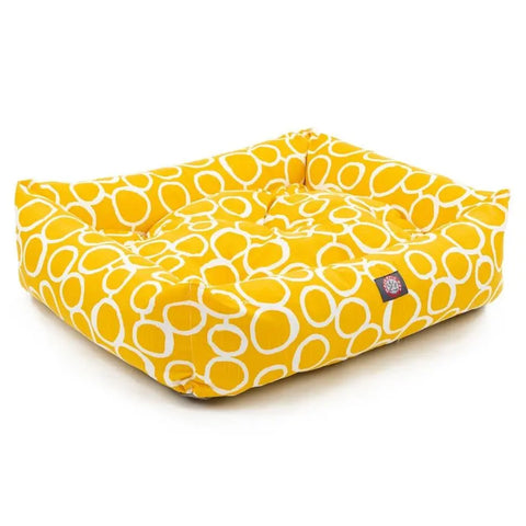 The Majestic Pet Fusion Luxe Bagel Bed is a square, yellow dog bed with cushioned sides, a white circular pattern, plush texture, machine-washable fabric for easy care, and a small black label on the side.