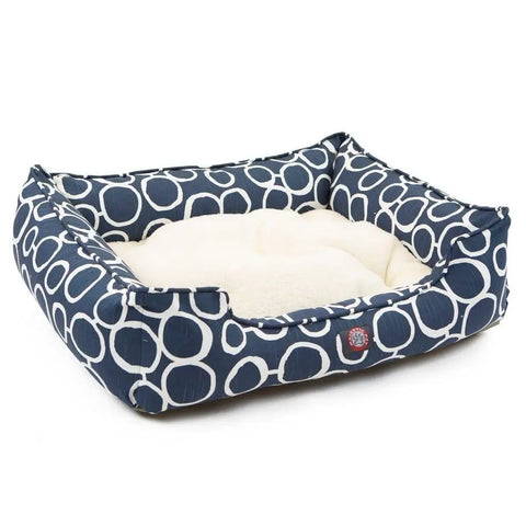 The Majestic Pet Fusion Contemporary Lounge Bed features navy blue sides with a white circle pattern, a soft cream cushion, raised edges, a front fabric logo, and durable machine-washable upholstery.