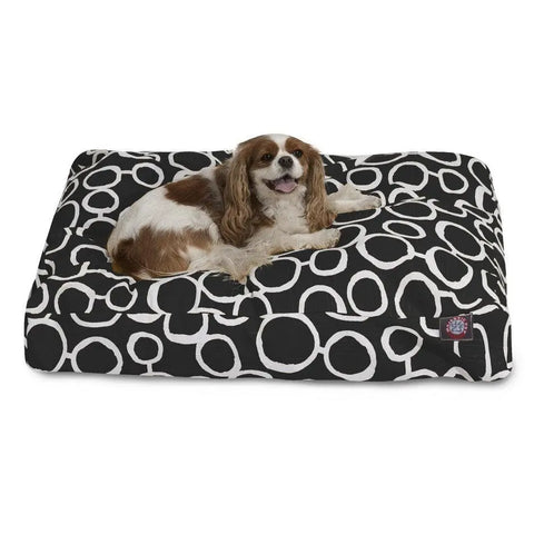 A brown and white dog relaxes on the Majestic Pet Fusion Memory Foam Dog Bed, featuring a black washable cover with a white circular pattern for easy cleaning and lasting comfort.