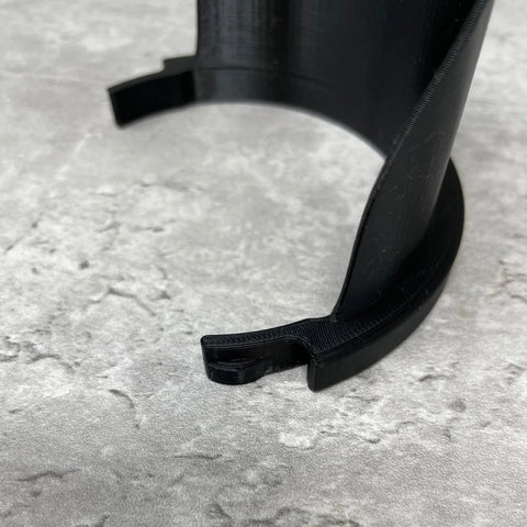 Close-up of the Chatelet Manufacturing Gallon Paint Pourer, a black, curved plastic accessory with a notched end, designed to fit gallon-sized paint cans and prevent spills.