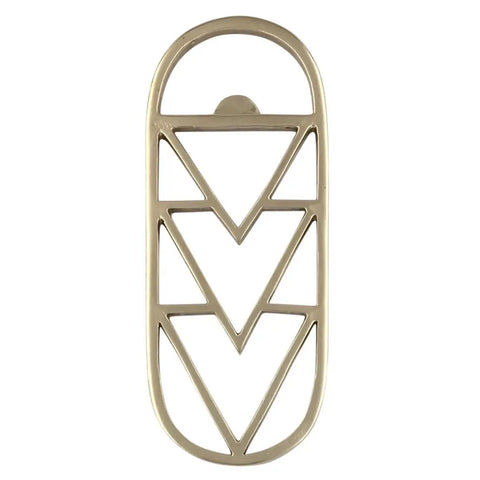 The BRASS GEO BOTTLE OPENER by Sarah Cecelia features three stacked chevrons in an elongated oval frame, blending geometric brass design with modern style and American-made craftsmanship.
