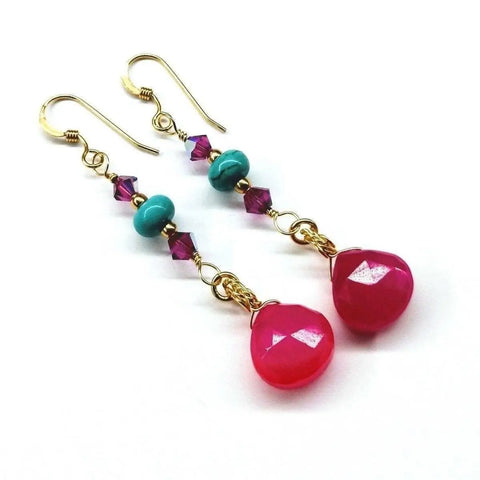 The Gold Filled Wire Wrapped Pink and Turquoise Gemstone Earrings by Alexa Martha Designs feature dangling pink chalcedony, turquoise beads, purple crystals, and teardrop gems on gold hooks, shown on a white background.