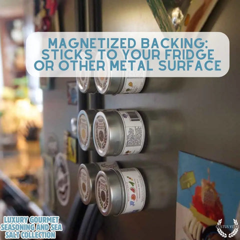 Several small tins from the Gustus Vitae Gourmet Seasoning and Sea Salt Gift Set – 6 Tin Collection cling easily to the fridge door, their magnetic backs highlighted by overlay text. The kitchen can be seen in the background.